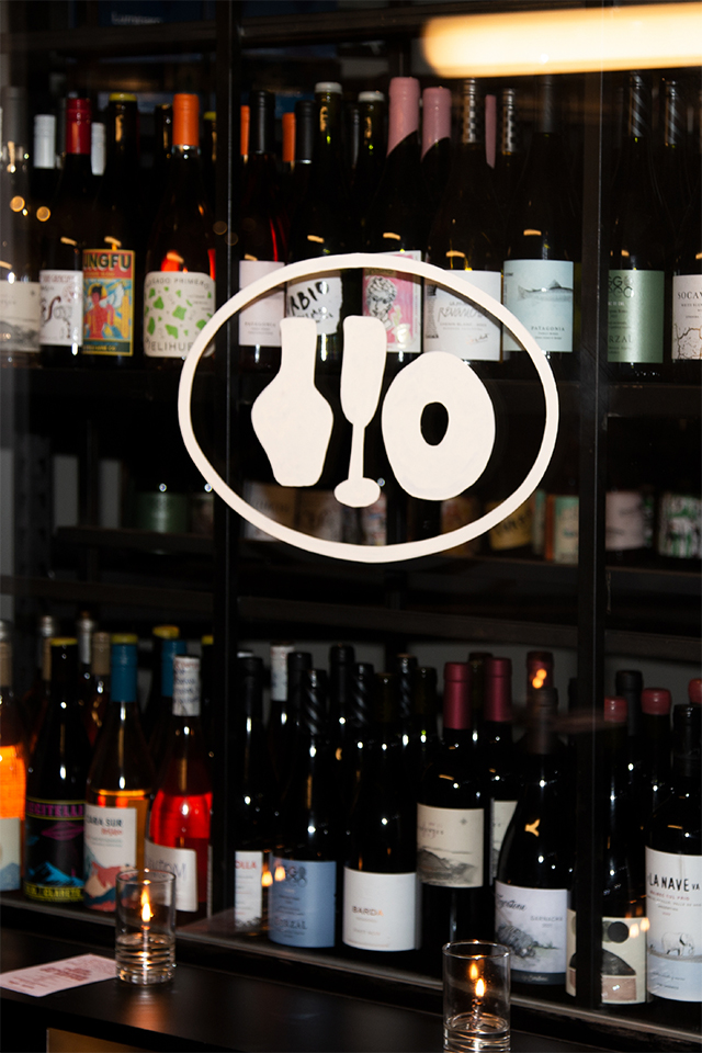 Botellas de vino detrás del vidrio con el logo distintivo de copas de Tresca.